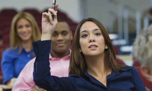 female executive raising hand during training