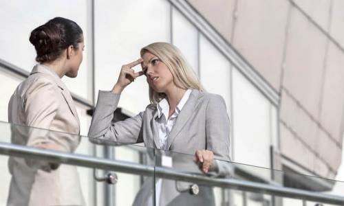 two businesswomen arguing in office corridor
