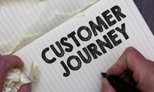 notebook with customer journey written on page
