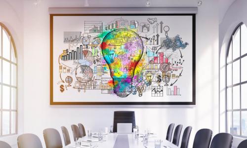 large colorful light bulb sketch above the head of a boardroom table