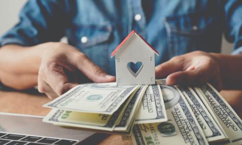 man with $100 bills, a house and a heart