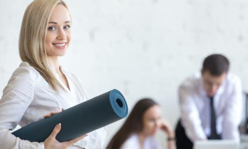 business woman carries yoga mat in the office
