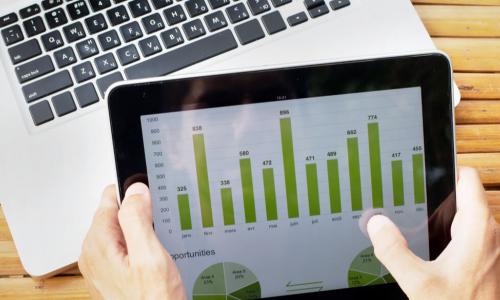 hands on tablet with charts
