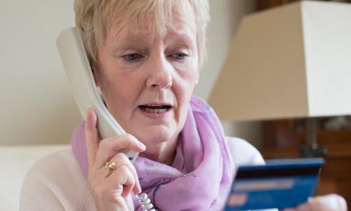 senior woman giving credit card information on phone