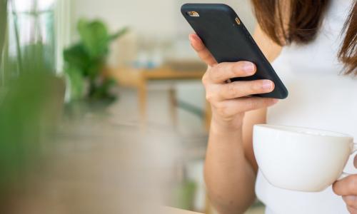 woman drinking coffee with smartphone