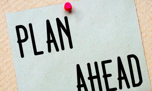 plan ahead printed on recycled paper stuck with red pin to cork board