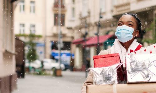 woman holiday shopping with packages and snow