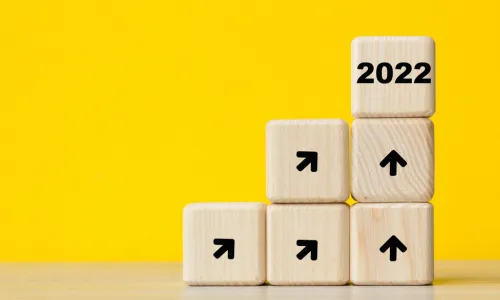 stack of wood blocks with arrows pointing up to a 2022 block at the top of the stack