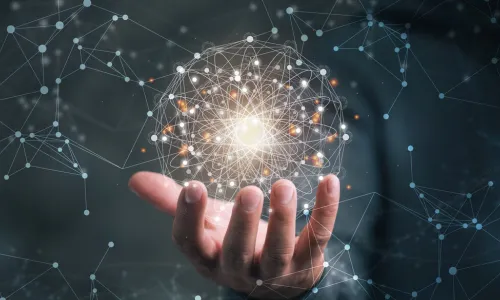 businessman holding circle containing glowing global network in his hand