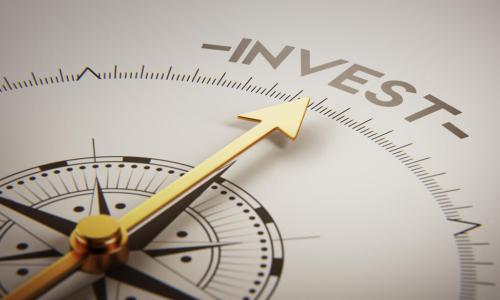 golden arrow on a compass points to the word invest