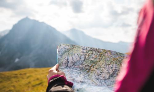 girl navigating mountains with topographic map