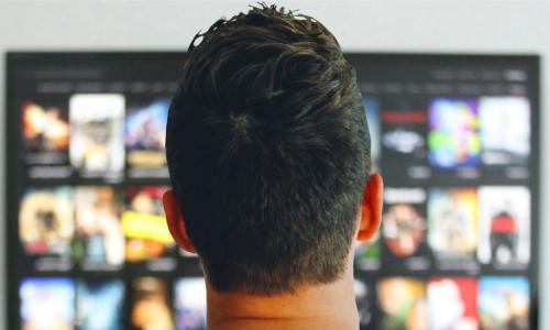 man watches his connected TV with many show choices
