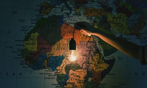 hand with light bulb in front of map of Africa