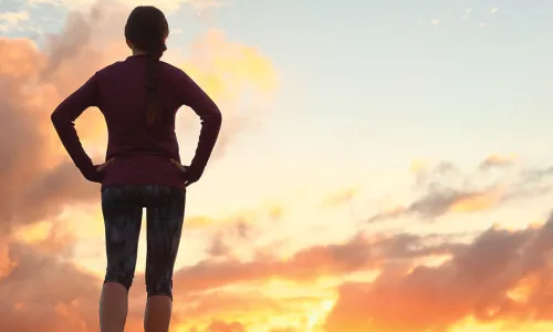 jogger observes sun rising over horizon