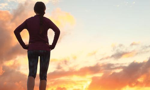 jogger observes sun rising over horizon