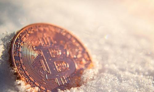 shiny physical bitcoin laying in the snow