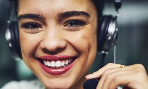 smiling young woman using headset in call center