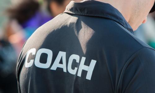 View of the back of a coach wearing a black shirt