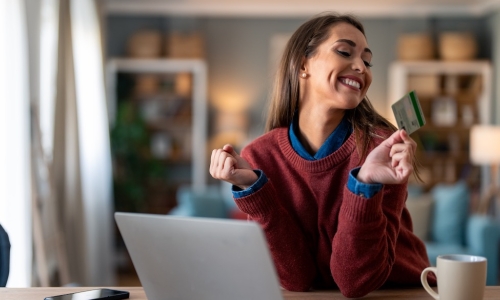 happy young woman reviewing earned credit card rewards