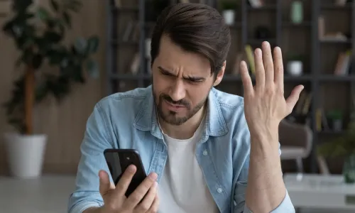 upset young man looking at phone