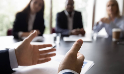 hands openly extended explaining around a board table