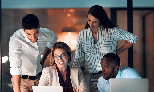 Group of individuals looking at laptops