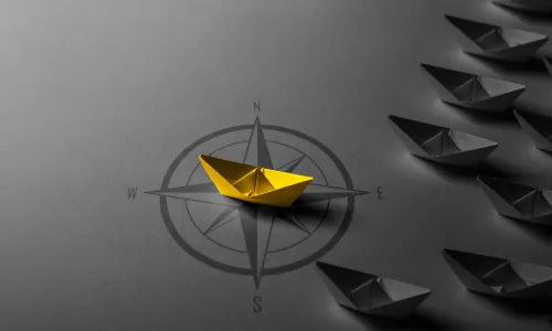 paper boat on compass