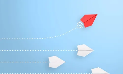 one red paper airplane flying it's own course away from 3 white paper airplanes